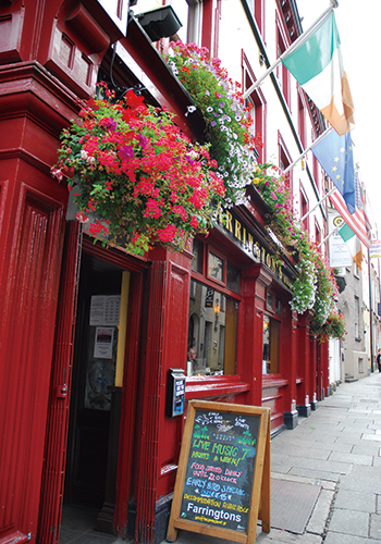 ビビッドな壁の色と飾られた花がかわいらしいアイルランドのパブ